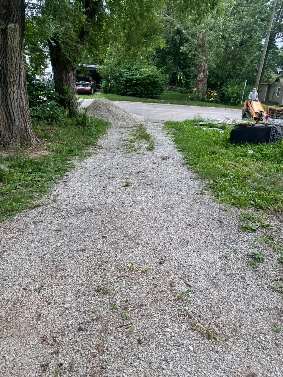 Narrow washed-out gravel driveway before regrading
